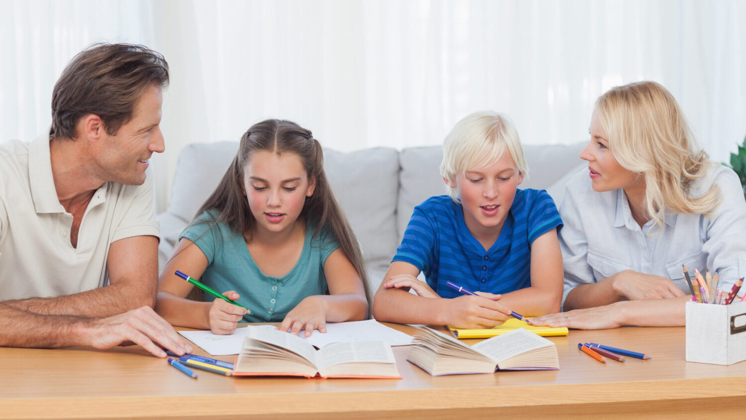 Parents helping their children doing their homework in living room